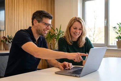 Tim shows a client something on her laptop.